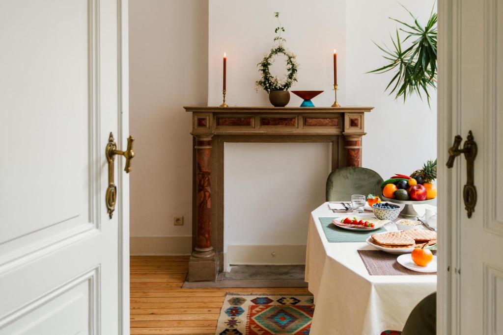 een eetkamer met een tafel en een open haard bij Ambiorix Residence in Brussel