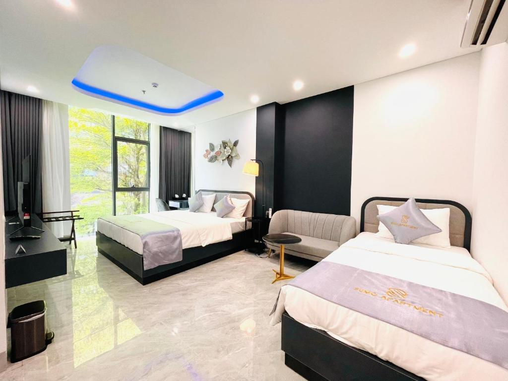 a hotel room with two beds and a blue ceiling at SUMO HOTELS in Da Nang