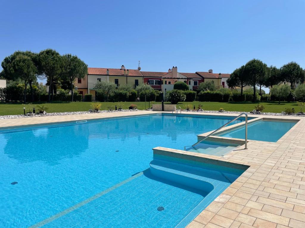 a large swimming pool with blue water at LunaSole Casa vacanza mare in Aprilia Marittima