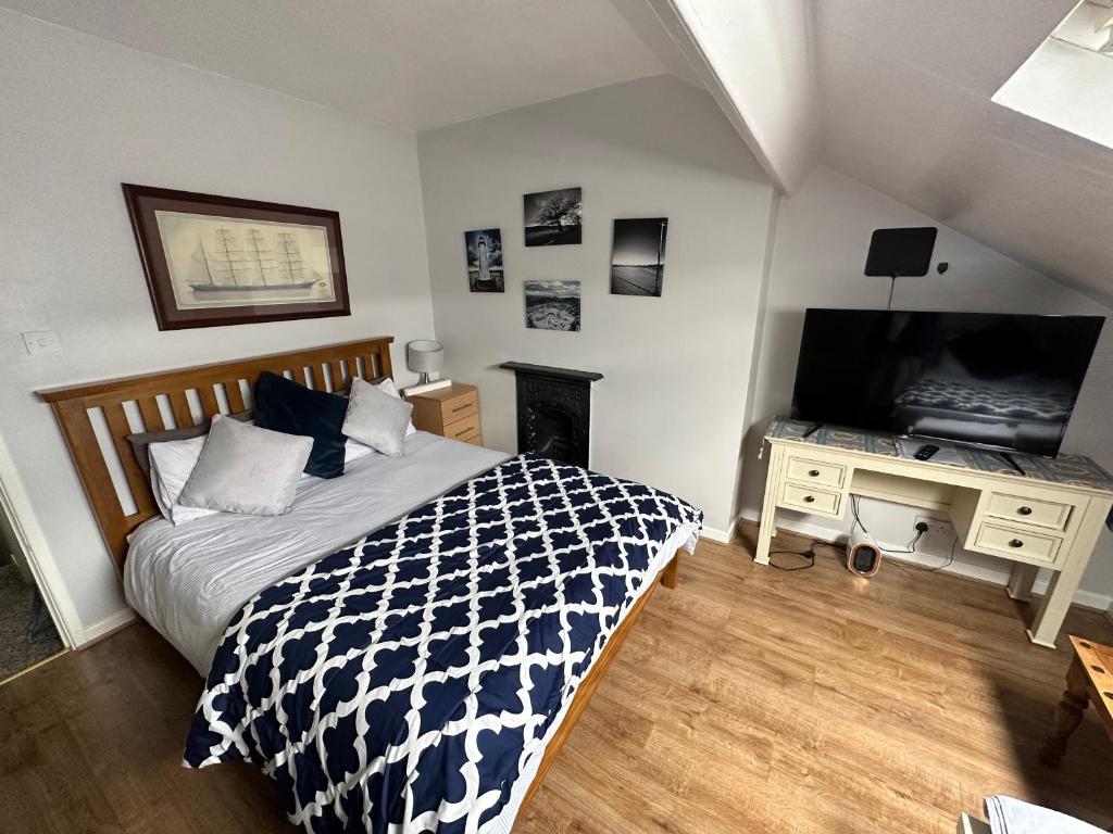 a bedroom with a bed and a desk with a television at Belfast Duplex Apartment Siren Stays in Belfast