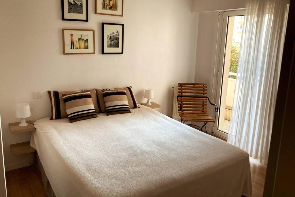 a bedroom with a large bed and a window at Appart Hypercentre Biarritz - PKG &#47; WIFI &#47; 4-6 Personnes in Biarritz