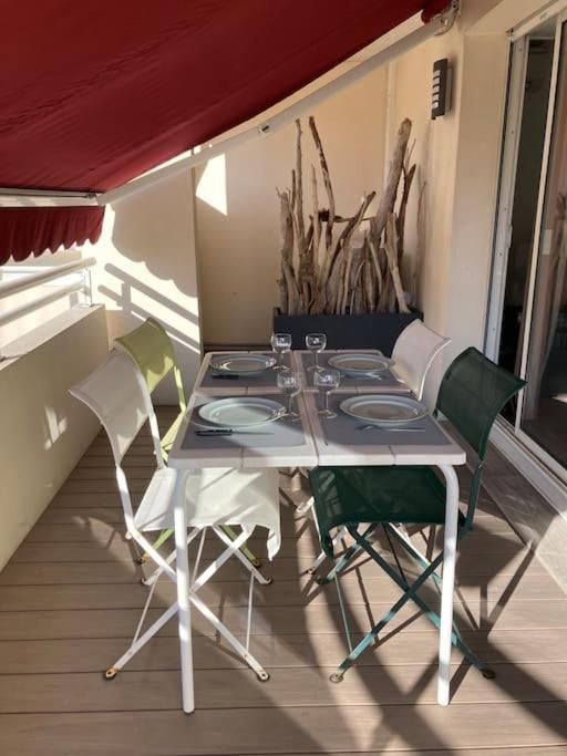 a table and chairs sitting on a balcony with a table and chairs at Appart Hypercentre Biarritz - PKG &#47; WIFI &#47; 4-6 Personnes in Biarritz