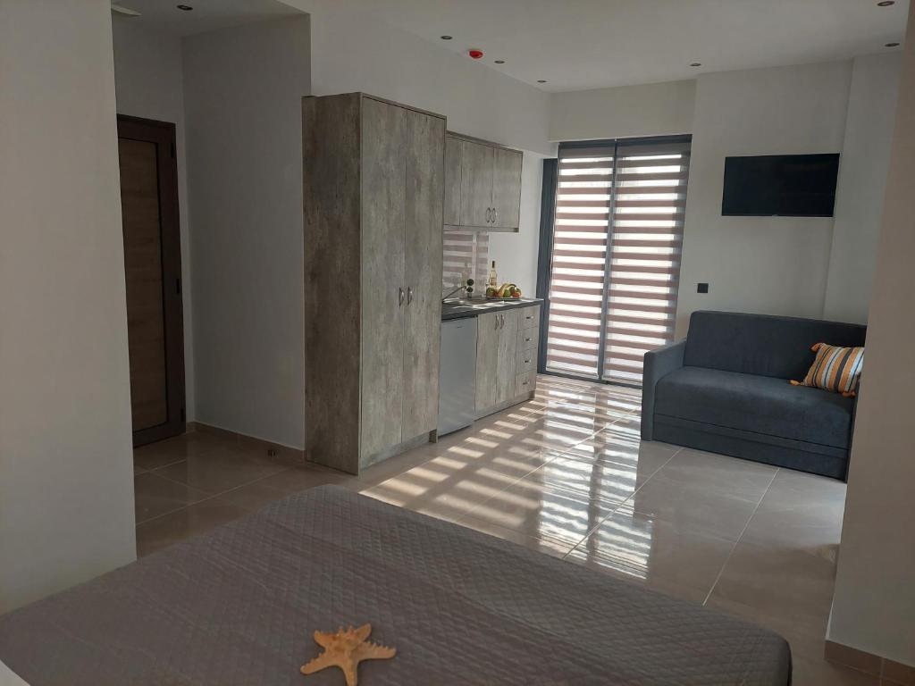 a living room with a blue couch and a kitchen at Luana Monte Apartments in Amoudara Herakliou