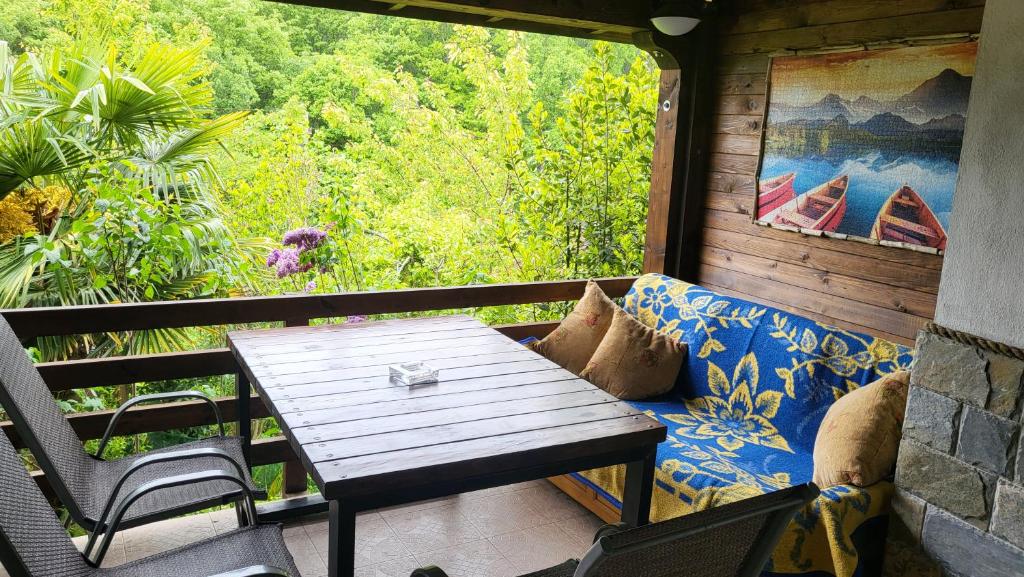 una mesa y un sofá en un balcón con ventana en Guest House Fanny, en Sinemorets