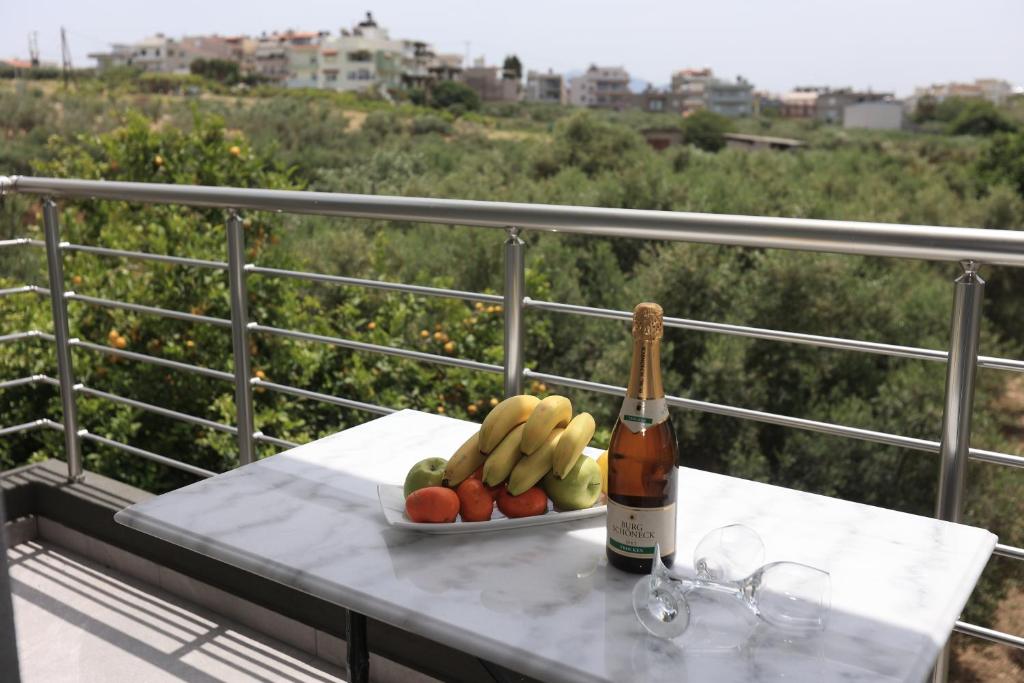 a bottle of wine and a plate of fruit on a table at Luana Monte Apartments in Amoudara Herakliou
