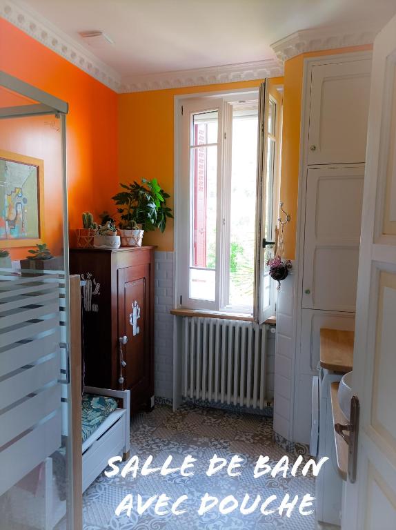 une chambre orange avec une porte et une fenêtre dans l&#39;établissement La Note Verte Pause en ville, à Foix