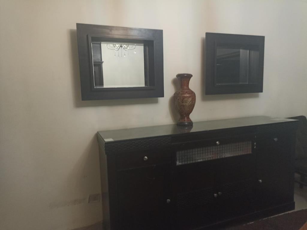 un vase assis sur une commode dans une pièce avec un miroir dans l'établissement Helioples .marghany, au Caire