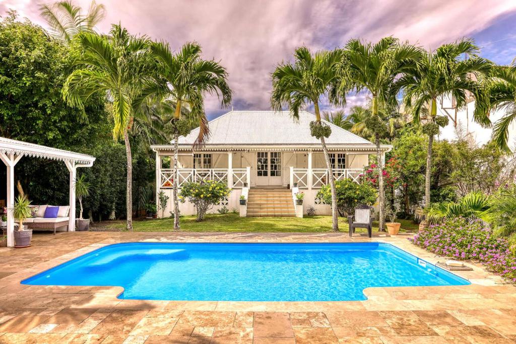 a house with a swimming pool in front of a house at La Case O zoizos in Saint-Joseph