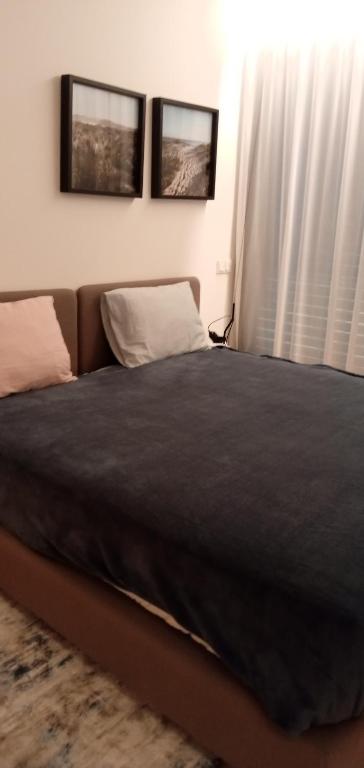 een bed in een slaapkamer met twee foto's aan de muur bij Casa do Escorrega in Grândola