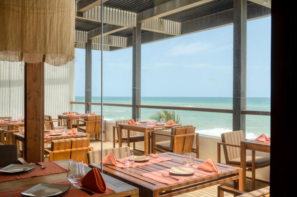 a restaurant with tables and a view of the ocean at Riff Hikkaduwa in Hikkaduwa
