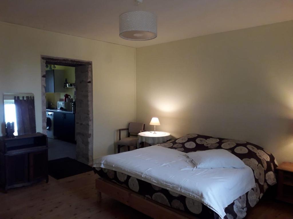 a bedroom with a bed and a room with a table at "Soleil" - appart étage 2 - Loc'h finistère - N6 in Quimper
