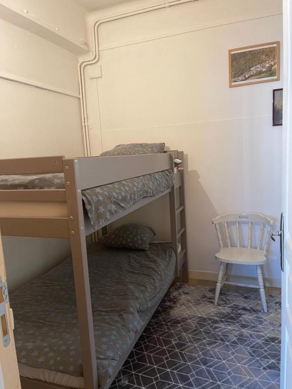 a bedroom with two bunk beds and a chair at Chez Léandre in Vitry-le-François