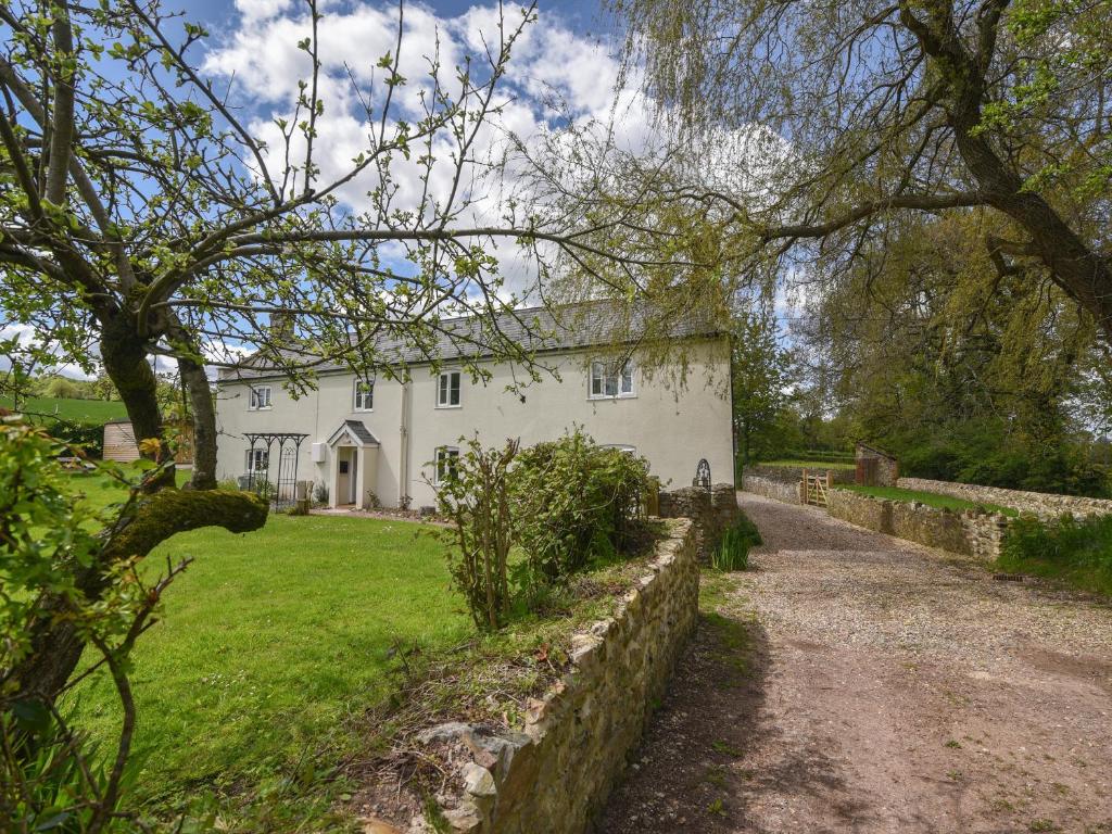 a white house with a path leading to it at Millwater Cottage in Axminster