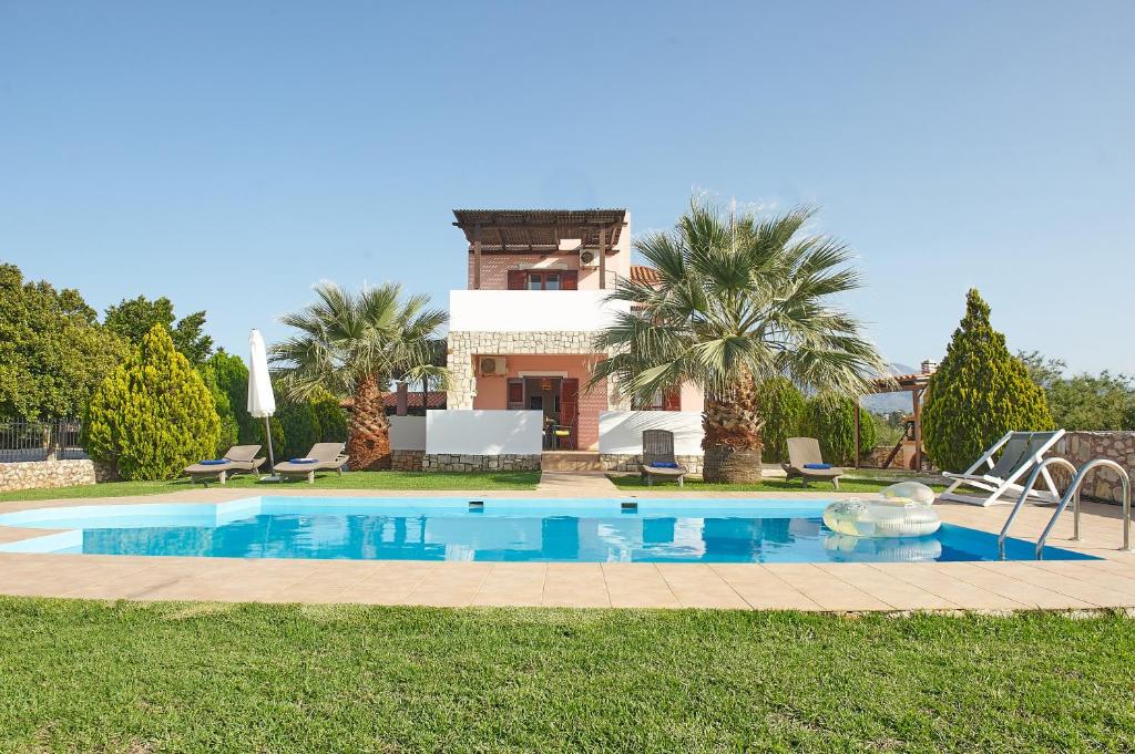 a villa with a swimming pool in front of a house at Dreamscape Residences - Villa Rafaella in Epáno Kefalás