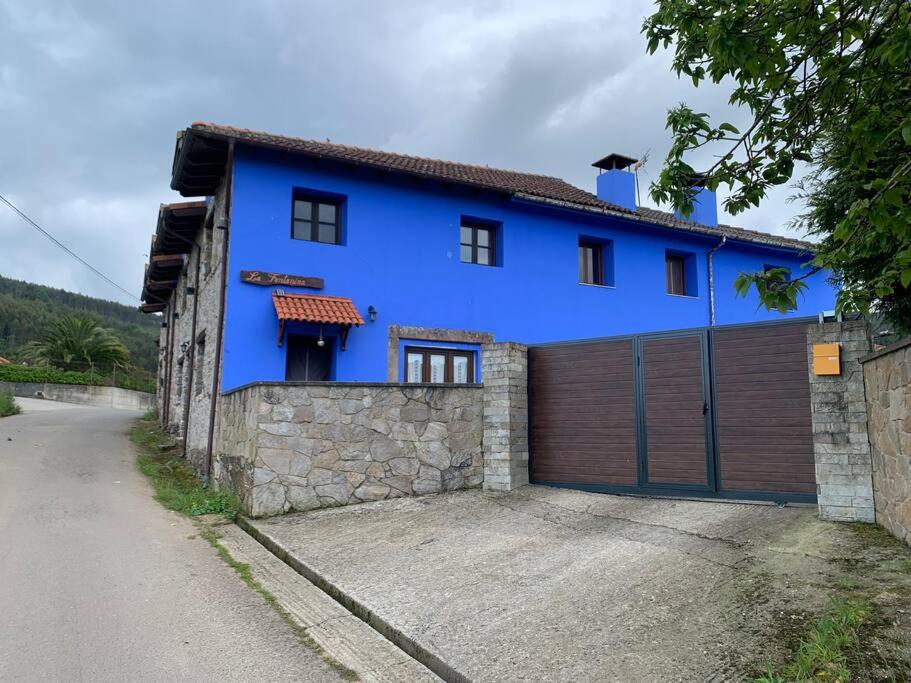 a blue house with a wooden garage at La Fontanina de Mario in Villaviciosa