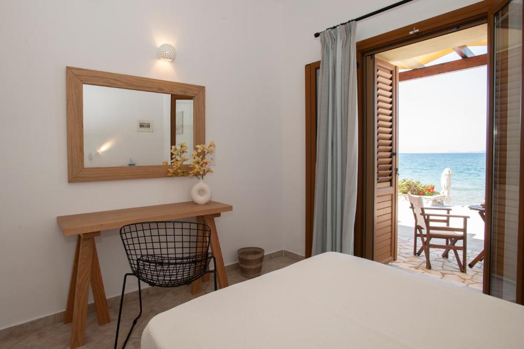 ein Schlafzimmer mit einem Bett, einem Spiegel und Meerblick in der Unterkunft Asterias Studios Finikounda in Finikounda