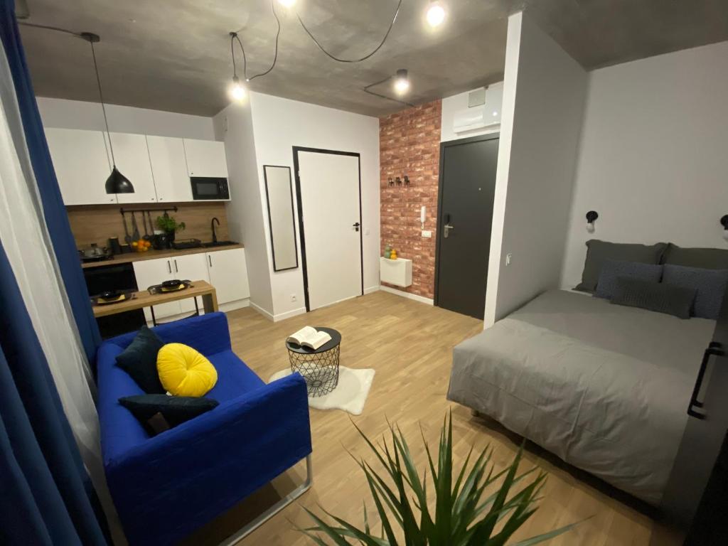 een woonkamer met een bed en een blauwe stoel bij Apartamenty Silver Place in Szczecin