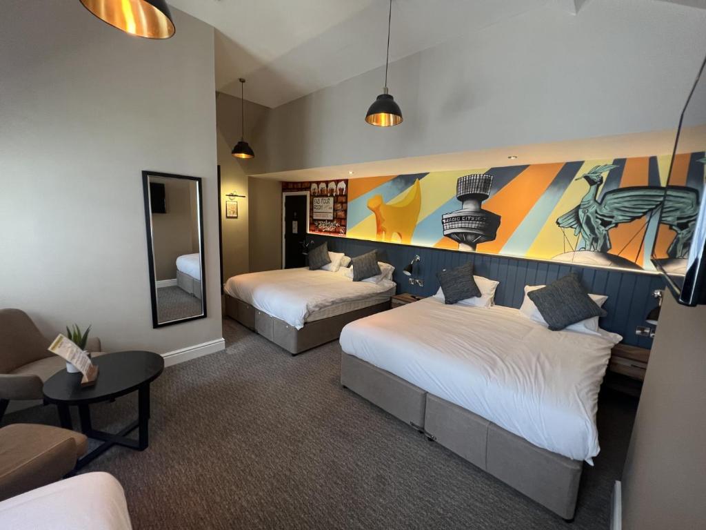 a hotel room with two beds and a mirror at Fenwick Sunrise Hotel in Liverpool