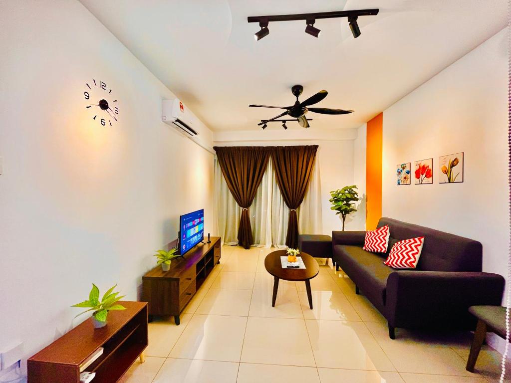 ein Wohnzimmer mit einem Sofa und einer Uhr an der Wand in der Unterkunft P1 PineComfyStay Waterpark 7pax Ipoh in Kampong Pinji
