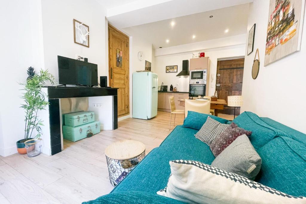un salon avec un canapé bleu et une cuisine dans l'établissement #B1 Chez Giuseppe City center pedestrian streets, à Grenoble