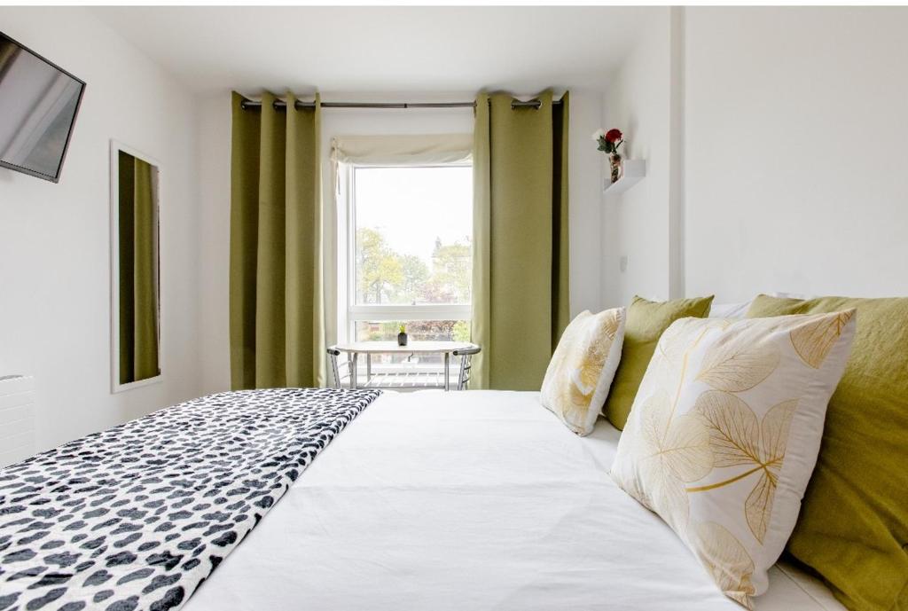a bedroom with a large white bed and a window at Double Room Charlotte in London