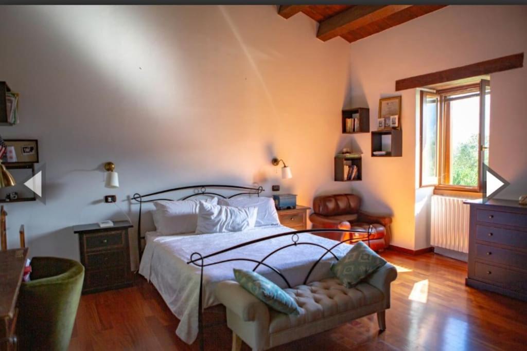 1 dormitorio con 1 cama, 1 silla y 1 ventana en Casa Nella Natura, en Boiano