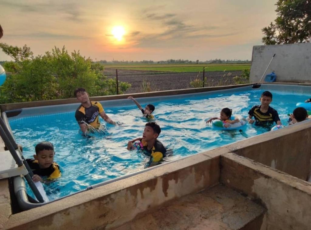 un grupo de personas en una piscina en Homestay Anjung Malinja Private Pool Kedah, en Yan