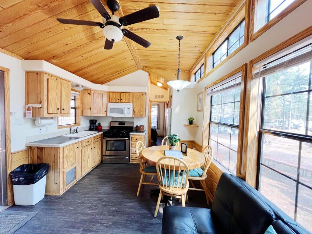 a kitchen with a table and a ceiling fan at Sally's Cabin is a quaint two bedroom tiny home in Woodland Park