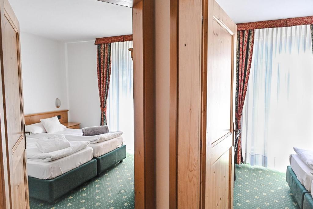 Łóżko lub łóżka w pokoju w obiekcie Alp Hotel Dolomiti