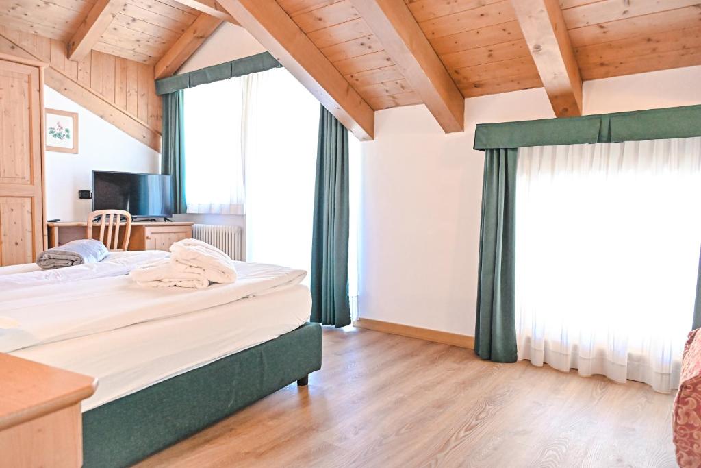 Łóżko lub łóżka w pokoju w obiekcie Alp Hotel Dolomiti