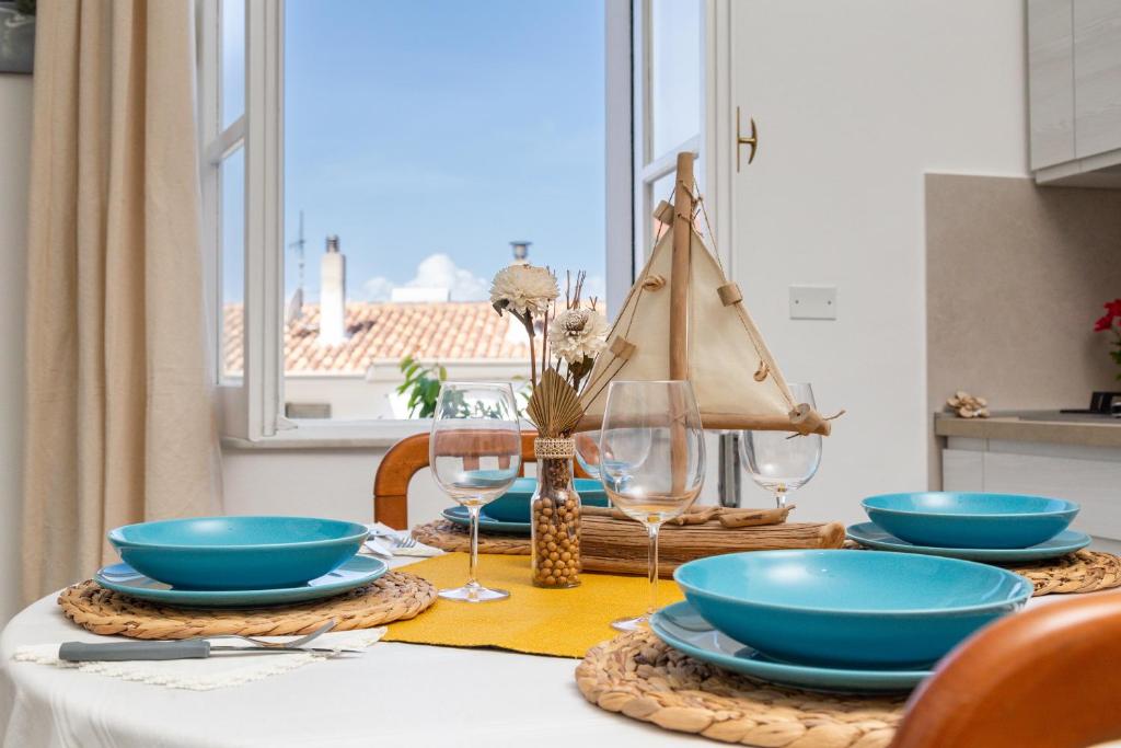 un tavolo con ciotole e piatti blu sopra di Appartamento A_Mati a Baunei a Baunei