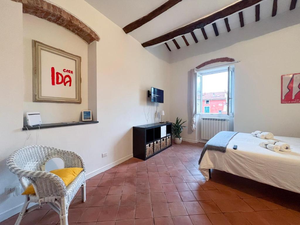 um quarto com uma cama e uma cadeira num quarto em Casa Ida em Lerici