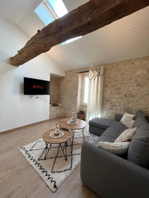 un salon avec un canapé et une table dans l'établissement La Pierre Pourpre, à Eymet