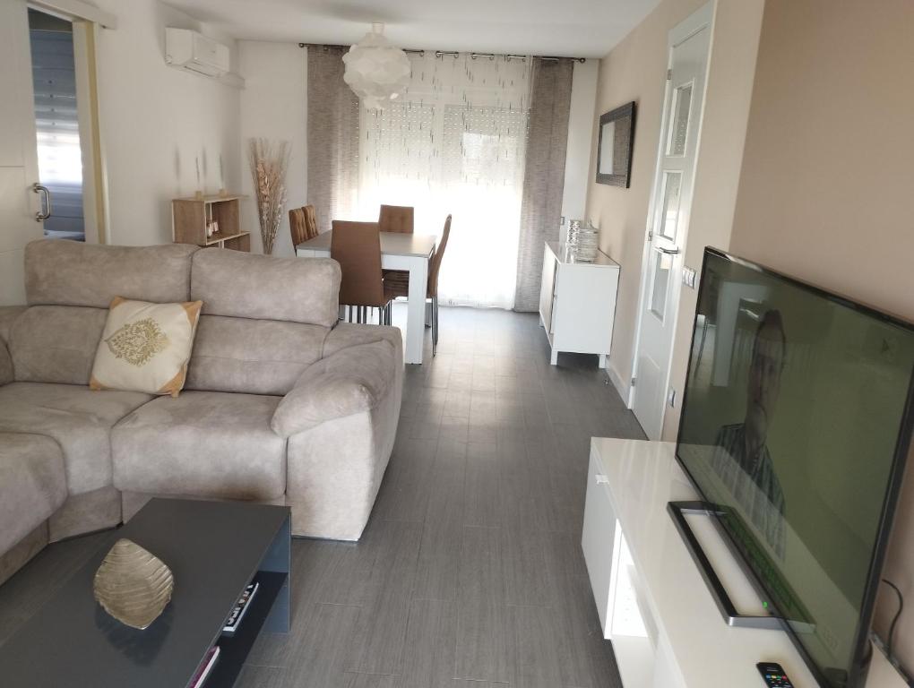 sala de estar con sofá y TV de pantalla plana en Ático frente al mar con parking para 5 personas, en Calafell