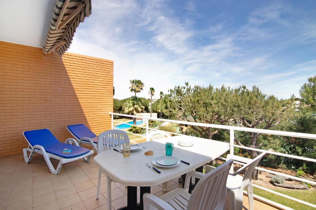een patio met een tafel en stoelen op een balkon bij Yara Beach Apartments T1 in Albufeira
