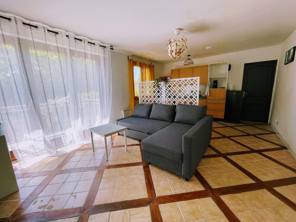 a living room with a couch and a table at Beau appartement près de la nature entre Disney et Paris in Noisy-le-Grand