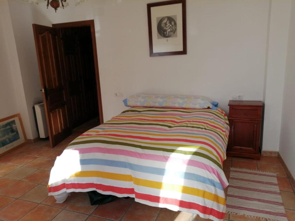 łóżko w pokoju z kolorowym kocem w obiekcie La Casita Azul w mieście Grazalema