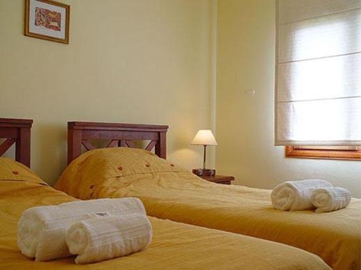 two beds in a bedroom with towels on them at Hosteria Miyazato Inn in El Calafate