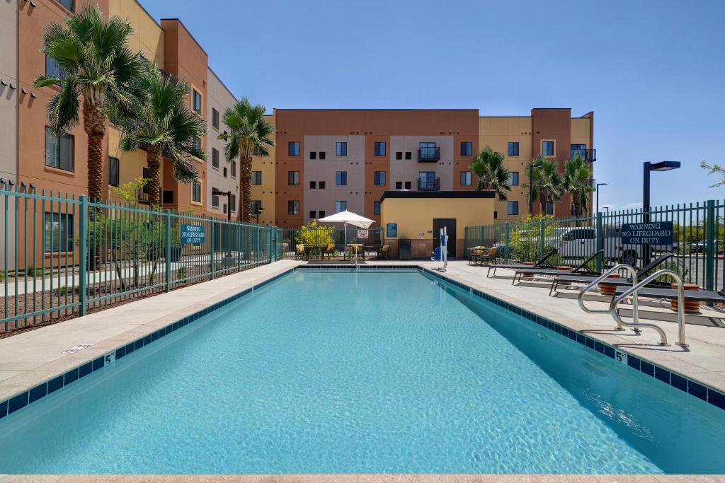 a swimming pool at a apartment complex with palm trees and buildings at WaterWalk Phoenix - North Happy Valley in Phoenix