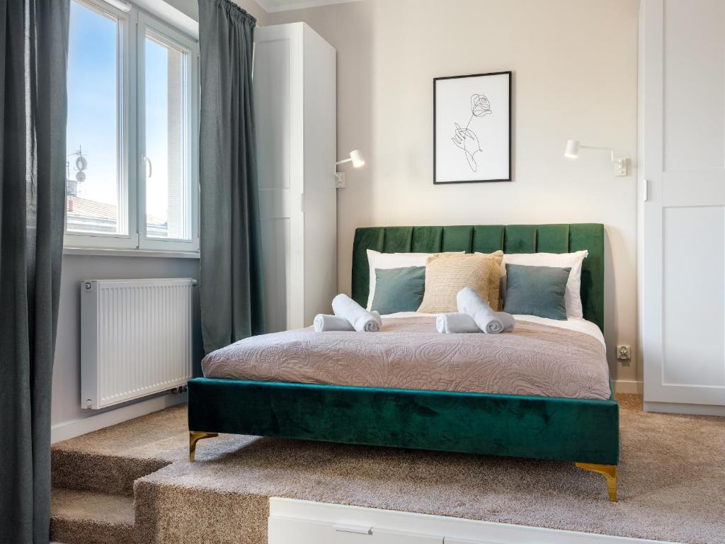 sypialnia z zielonym łóżkiem i oknem w obiekcie Tyzenhauz Apartments Rakowicka Street w Krakowie