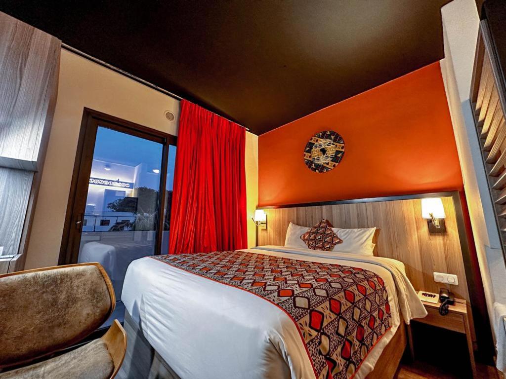 um quarto de hotel com uma cama e uma janela em ONOMO Hotel Bamako em Bamako