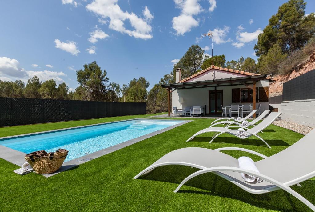 a backyard with a swimming pool and green grass at Les Roques in Castellnou de Bages