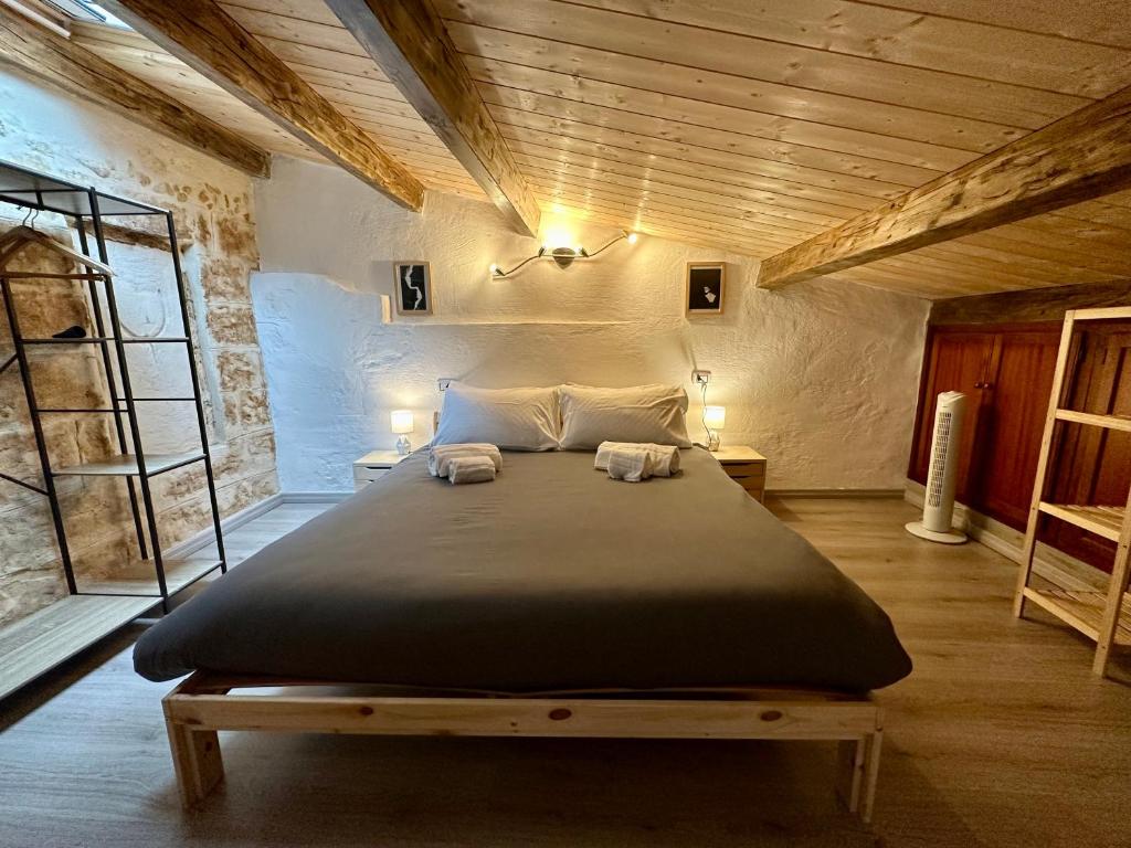 1 dormitorio con 1 cama grande y 2 toallas. en SASSARI-CENTRO Elegante Appartamento con WiFi e Netflix, en Sassari