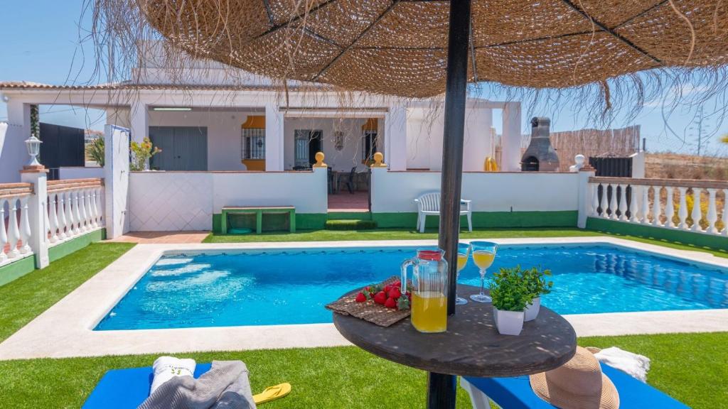 una mesa con bebidas junto a una piscina en Villa Quevedo Torrox by Ruralidays, en Torrox
