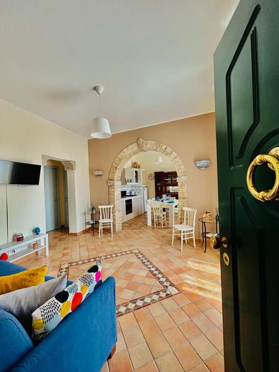 a living room with a blue couch and a kitchen at Casa Amelia - Charme in Taormina in Taormina