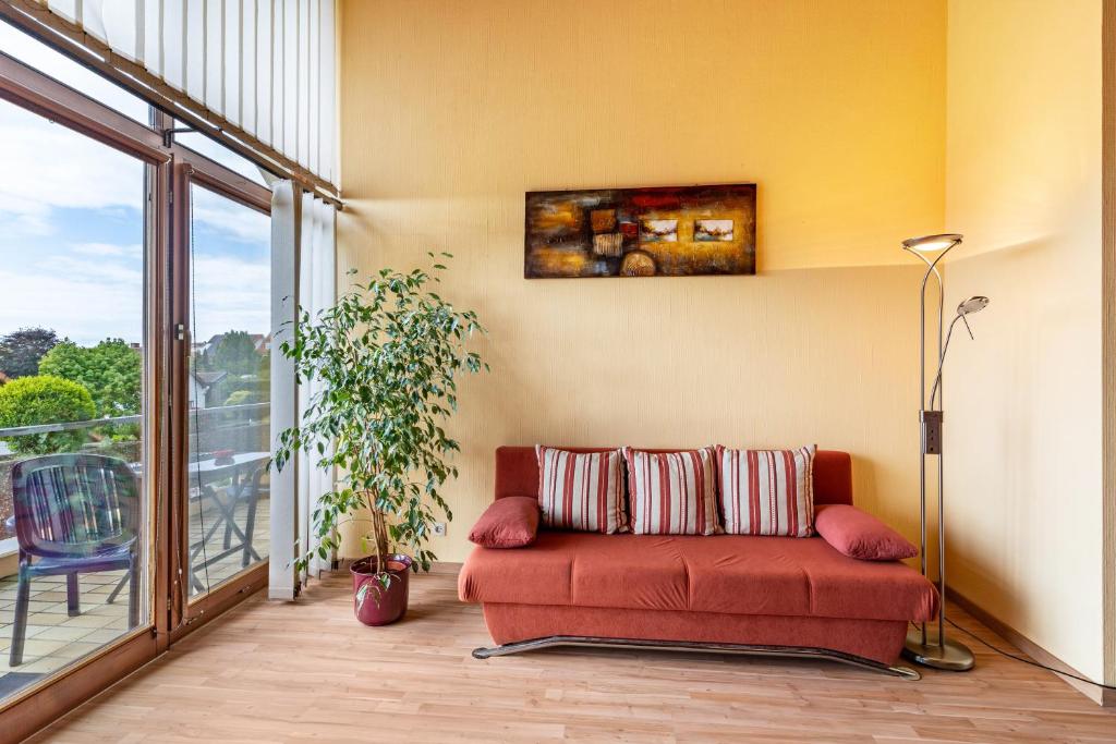 フリーゼンハイムにあるMarleneのバルコニー付きの客室で、赤いソファが備わります。