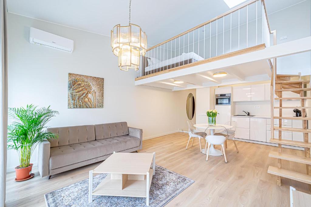 ein Wohnzimmer mit einem Sofa und einem Tisch in der Unterkunft Modern Loft Apartment w/free parking No.2 in Marijampolė