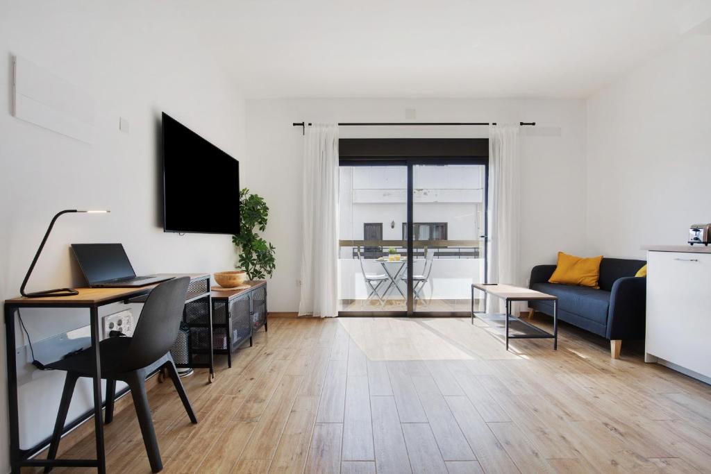 a white living room with a desk and a couch at Estudio Erbania in Gran Tarajal