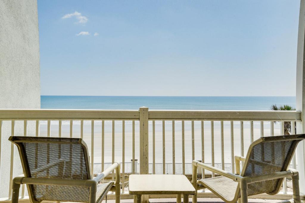 duas cadeiras e uma mesa numa varanda com praia em Daytona Beach Vacation Rental with Beach Access em Daytona Beach