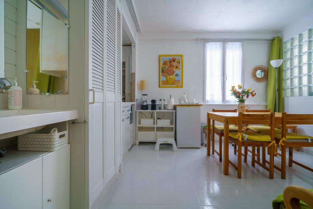 a kitchen and dining room with a table and chairs at Logis Helena in Elne